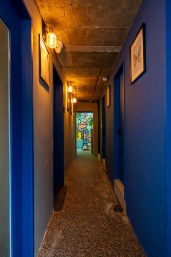an empty corridor with blue walls and a hallway with a corridorngthngthngthngth at Hithere guesthouse in Seoul