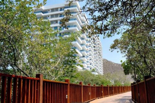 a tall white building in the background with a fence at ESPECTACULAR APARTAMENTO EN SAMARIA CLUB DE PLAYA smr in Gaira