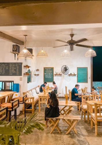 a group of people sitting at tables in a restaurant at Vela Terraces Hotel in Coron