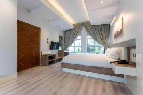 a bedroom with a large bed and a large window at Talah Resort in Riyadh