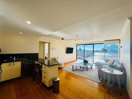 a kitchen and living room with a couch and a table at River Plaza Apartments Brisbane Southbank in Brisbane