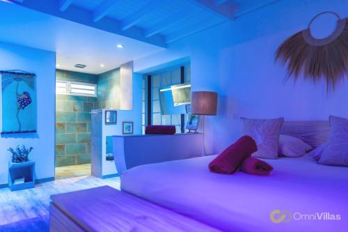 two beds in a bedroom with blue walls at Luxurious 4BR Villa 
