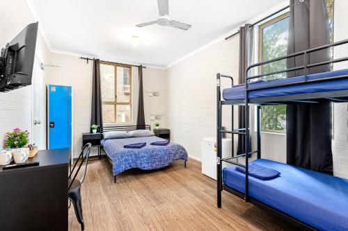 a bedroom with two bunk beds and a bed at Newtown Backpackers in Sydney