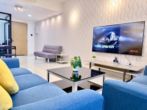 a living room with blue couches and a flat screen tv at MidValley Southkey Mosaic 6-9pax Netflix-SmartTV70inch in Johor Bahru