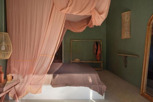 a bedroom with a bed with pink curtains and a mirror at Casa Tikiri - BOUTIQUE HOTEL Adults-Only in Ahangama