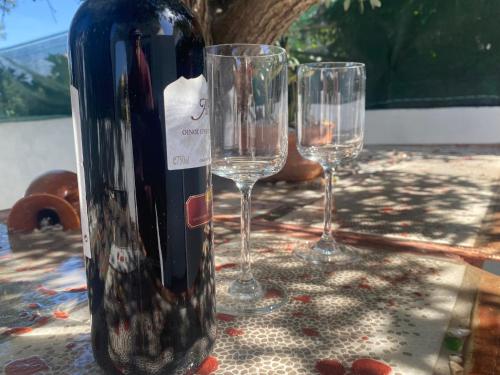 a bottle of wine and two wine glasses on a table at Flowers Lullaby Loft in Afantou