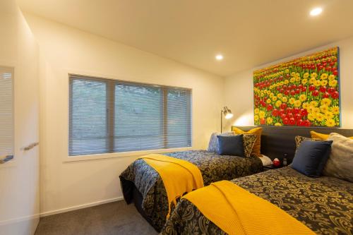 a bedroom with two beds and a painting on the wall at Amazing Lake Views in Queenstown