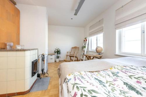 a white bedroom with a bed and a kitchen at Stylish and Cozy Studio Apartment in the Heart of Tallinn in Tallinn