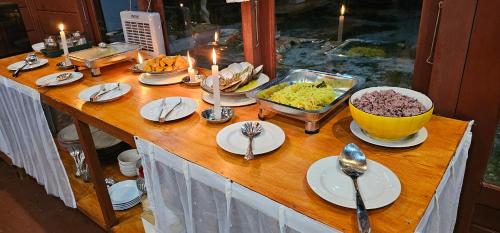 a table with plates and bowls of food on it at Raflow Resort Raja Ampat in Tapokreng