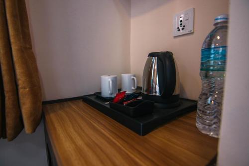 a table with a coffee maker and a bottle of water at Sandai Homes in Pātan