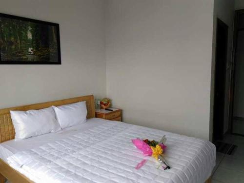 Un dormitorio con una cama con una flor rosa. en Bắc Nam Hotel DN by - BAY LUXURY, en Da Nang