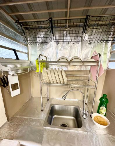 a sink in a kitchen with a shelf above it at K Inn 55 in George Town