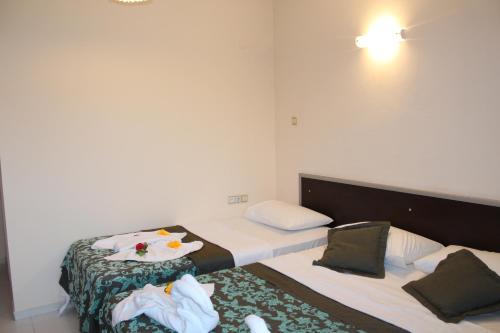 a bedroom with a bed with a plate of food on it at Hotel Gold Stone in Beldibi