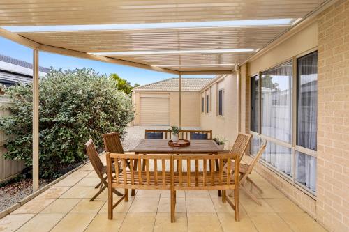 a patio with a wooden table and chairs at Coastal House Curlewis Getaway in Curlewis