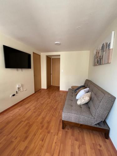 a living room with a couch and a flat screen tv at Departamento Estadio GNP antes foro sol, autodromo hermanos Rodríguez, palacio de los deportes, muy cerca de aeropuerto, CDMX in Mexico City