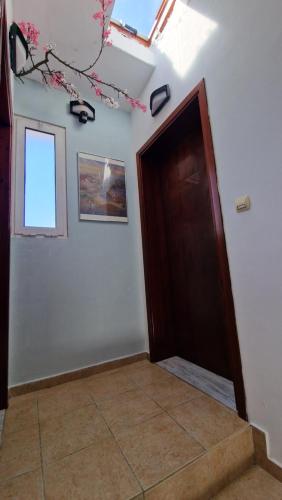 ein leeres Zimmer mit einer Tür und einem Fenster in der Unterkunft Kofinaki apartment 2 in Tycherón