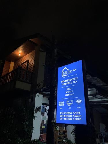 ein blaues Schild vor einem Gebäude in der Unterkunft Cozy Hub Hostel in Chiang Mai