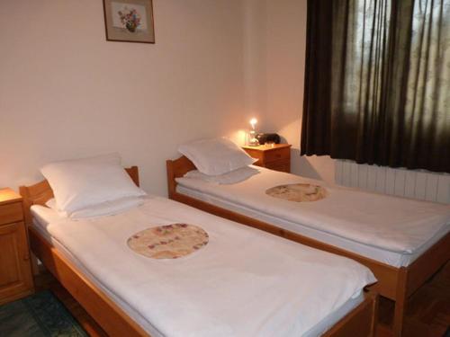 two twin beds in a room with a window at Niko Hotel in Samokov
