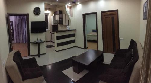 a living room with a table and chairs and a television at Tatev Apartments in Yerevan