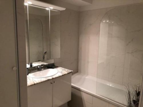 une salle de bain avec un lavabo et une baignoire dans l'établissement Appartement centre modern terrasse piscine parking, à Cannes