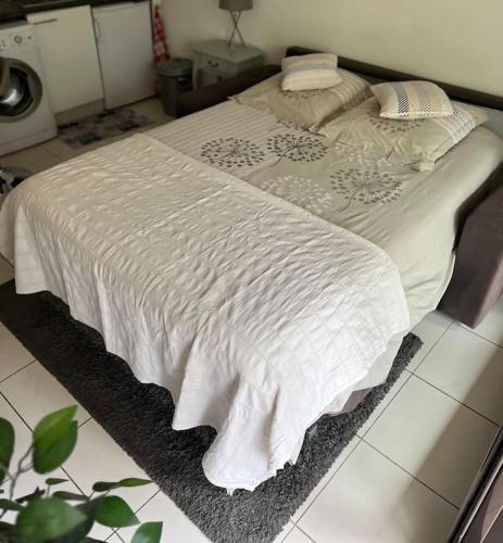 un lit avec une couverture blanche sur le sol dans l'établissement Appartement centre modern terrasse piscine parking, à Cannes