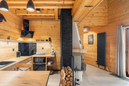 a kitchen with wooden walls and a fireplace at Apartamenty - Król Gór - in Wisła