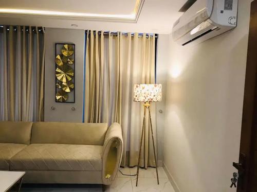 a living room with a couch and a lamp at Eiffle Tower View Apartments in Rāmkot
