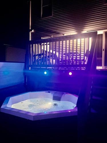a jacuzzi tub in a dark room with lights at Modern Vac Home, private Hot tub, close to airport in Moncton