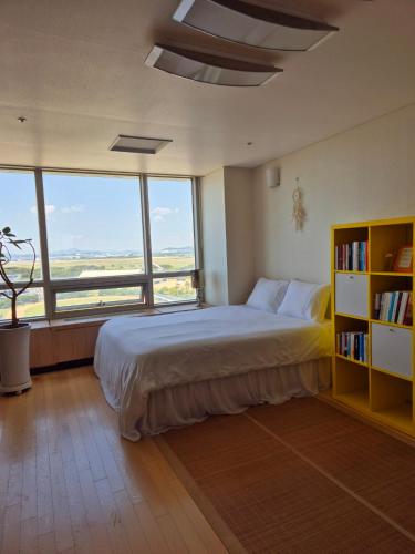 sypialnia z dużym łóżkiem i półką na książki w obiekcie Cozy Bright Studio w mieście Inczon