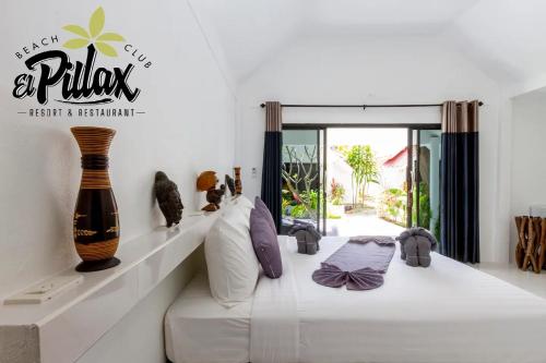 una camera da letto con un letto bianco e cuscini sopra di Lovely 1-Bed Chalet in El Pillax Koh Lanta a Ko Lanta