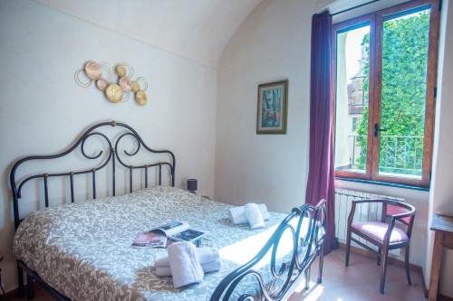 sypialnia z łóżkiem z 2 krzesłami i oknem w obiekcie Casa di Lella - Happy Rentals w San Remo