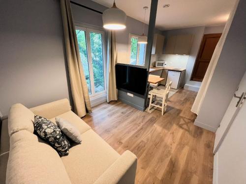 uma sala de estar com um sofá e uma sala de jantar em Pere Lachaise Apartment em Paris