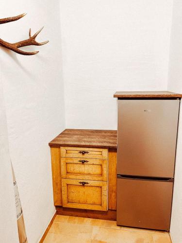 a kitchen with a refrigerator and a wooden cabinet at Zottlhoamat in Matrei in Osttirol