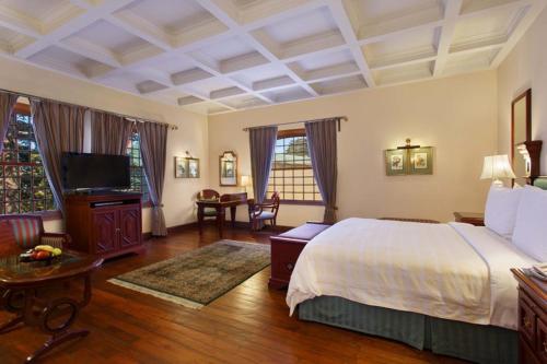 a bedroom with a bed and a television in it at The Oberoi Cecil in Shimla