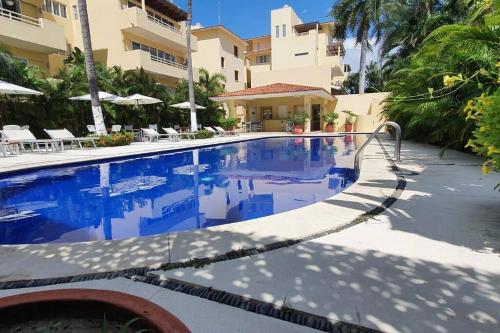 a swimming pool in front of a building at Nuevo Vallarta flamingos beach en bahia de banderas in Nuevo Vallarta