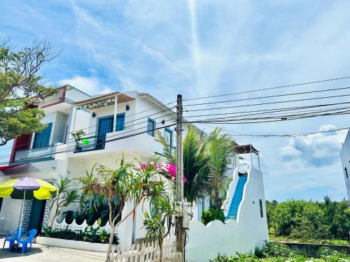a white house with a fence in front of it at Homestay Vitamin SEA - View Biển Phú Quý in Cu Lao Thu