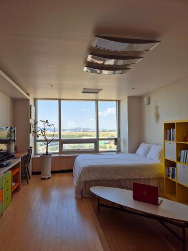 sypialnia z dużym łóżkiem i dużym oknem w obiekcie Cozy Bright Studio w mieście Inczon