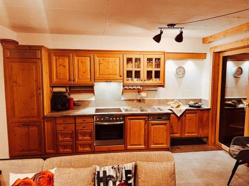 a kitchen with wooden cabinets and a stove top oven at Zottlhoamat in Matrei in Osttirol