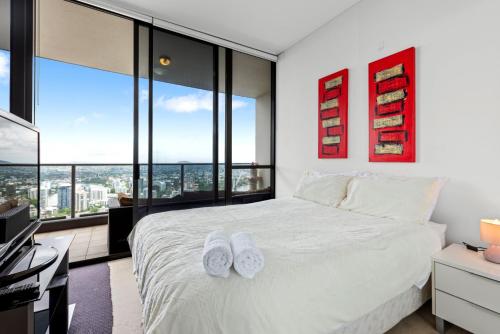 a bedroom with a bed with two white towels on it at Urban Skyline 2-Bed with Pool & Gym Access in Brisbane