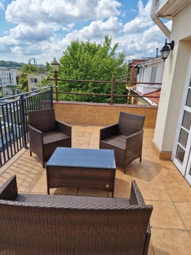 a patio with chairs and tables on a balcony at Centrum Noclegowe Apartament 5 in Bydgoszcz