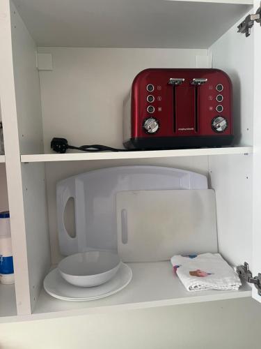 een kleine keuken met een rood apparaat op een plank bij Self contained room, en-suite with separate lockable front door, located in an exclusive area in Wednesbury