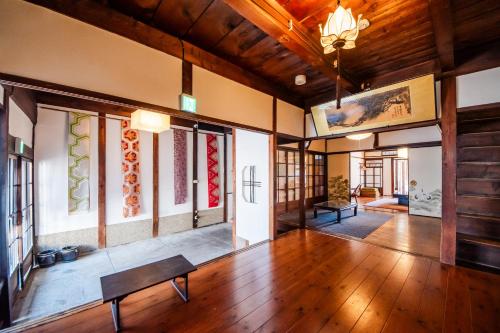 a living room with a wooden floor and a bench at Ranjatai in Nara