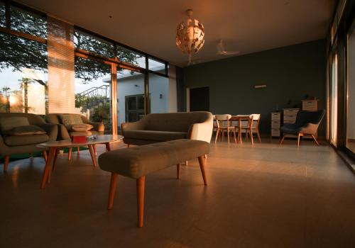 a living room with couches and a table and chairs at Hummingbird Beach House by EWA Properties in Manjeshwara