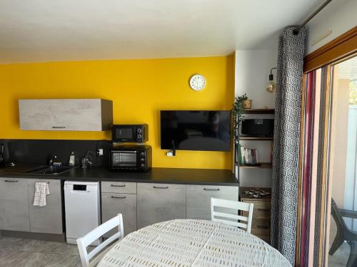 cocina con mesa y pared amarilla en Appartement 2pers Le Pouldu, proche plages, en Clohars-Carnoët