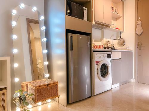 a kitchen with a refrigerator and a washing machine at Gold Coast PIK Apartments by Host Jess in Jakarta
