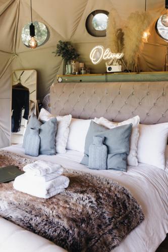 a bed in a tent with pillows on it at Beautiful Olive Pod Geo Dome House with Hot Tub in East Horsley