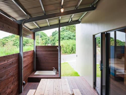 a bathroom with a tub and a glass door at Cottage Do in Nagura