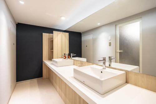baño con 2 lavabos y espejo grande en L stay＆grow晴海 en Tokio