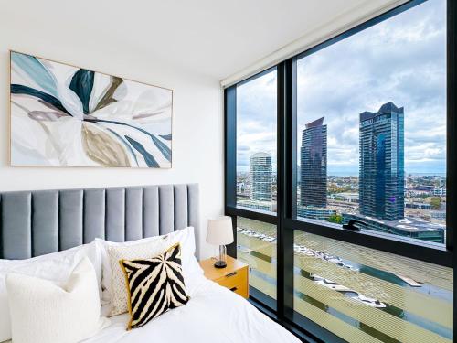 a bedroom with a bed and a large window at Brilliant Victoria Harbour Waterfront in Melbourne