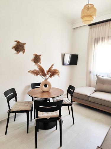 a living room with a table and chairs and a couch at Noelia House Ammouliani in Ammouliani